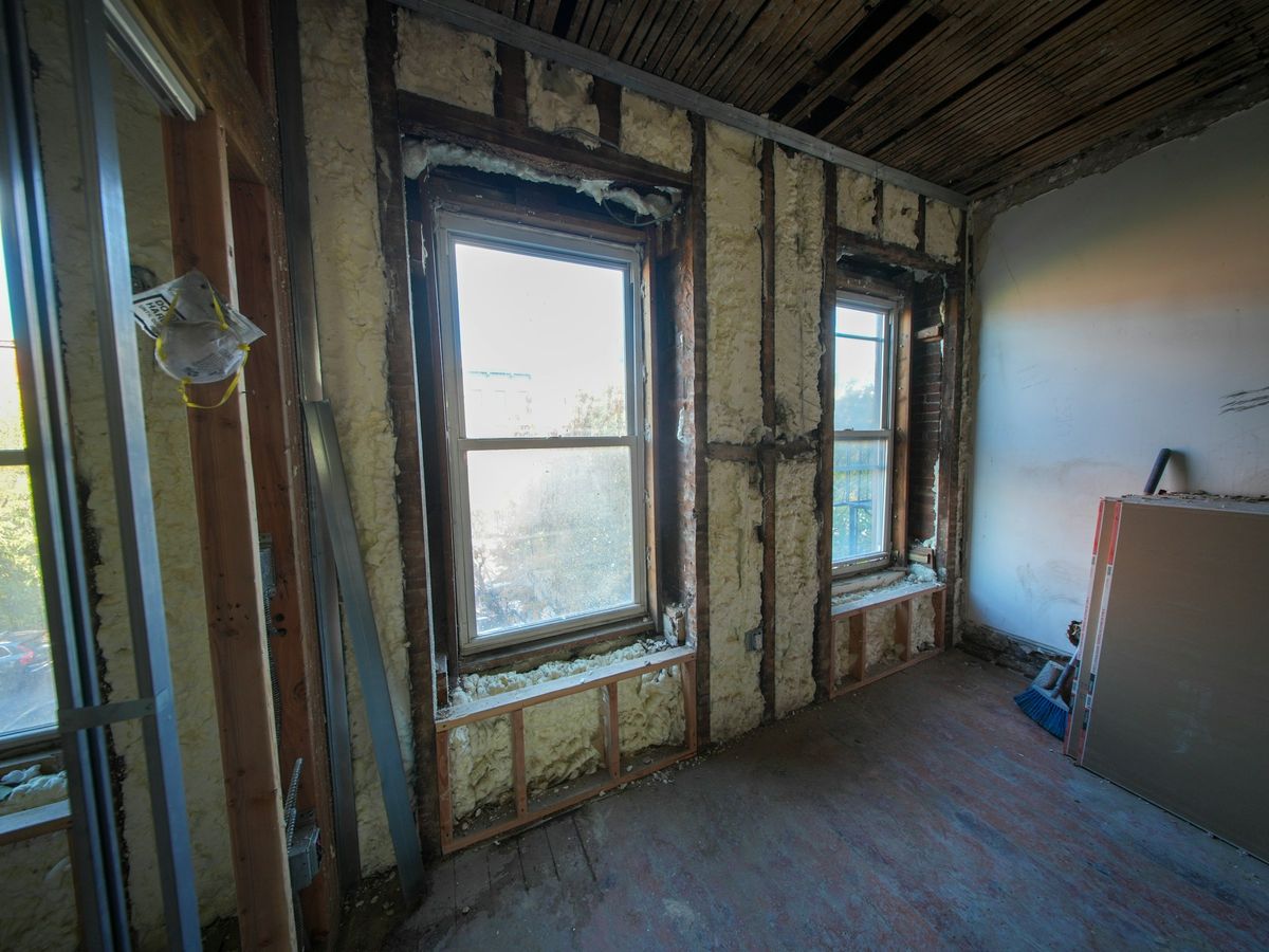 Kamer in renovatie: muren tot op het skelet uitgebroken en geïsoleerd, nieuwe gipsplaten tegen de wand
